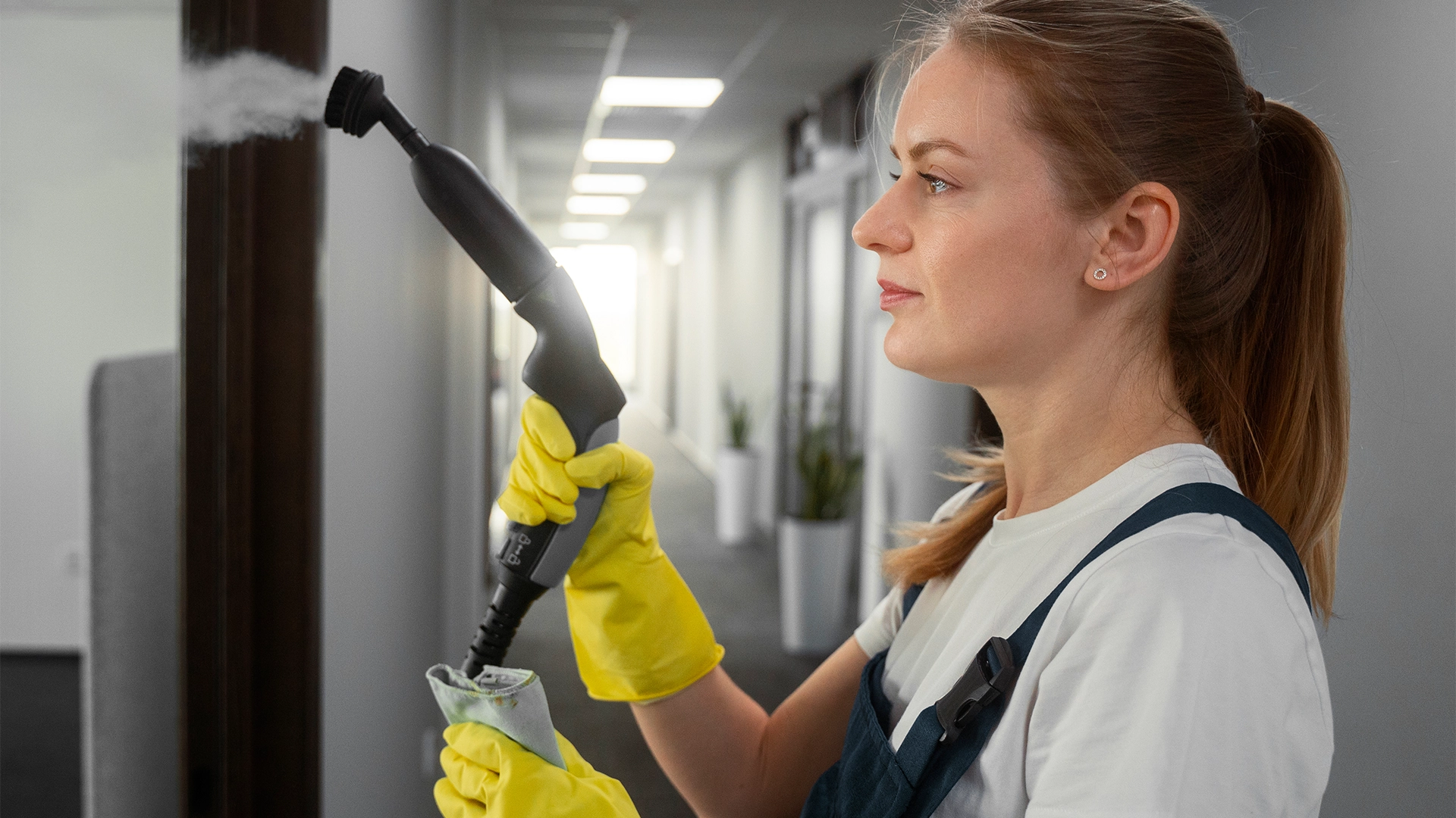 Maid in Ajman is cleaning the window with cleaner in her hand 