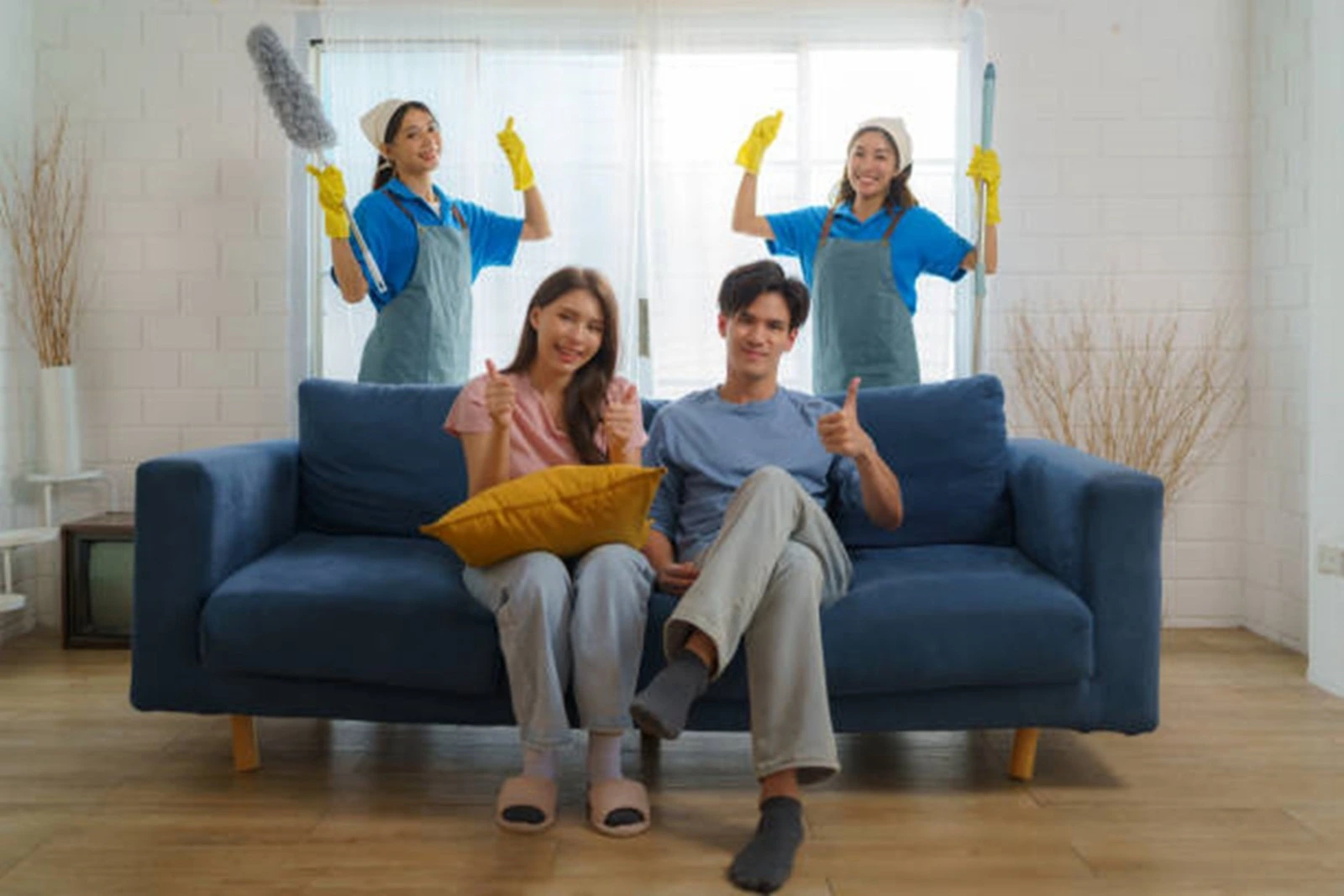 two maids are smiling along with their owner